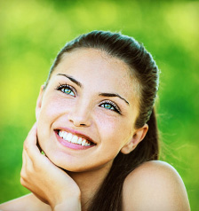 woman with bare shoulders laughs and looks up